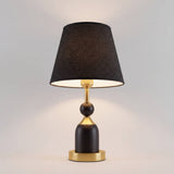 Lámpara de mesa ALBA BLACK AND GOLD encendida con luz cálida acogedora