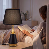 Mujer leyendo junto a la luz cálida de la lámpara de mesa negra