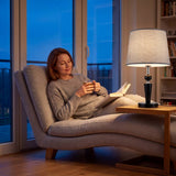 Mujer leyendo en el sillón junto a la luz cálida de la lámpara