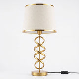 Lámpara de mesa Aurora con espiral dorada sobre fondo blanco