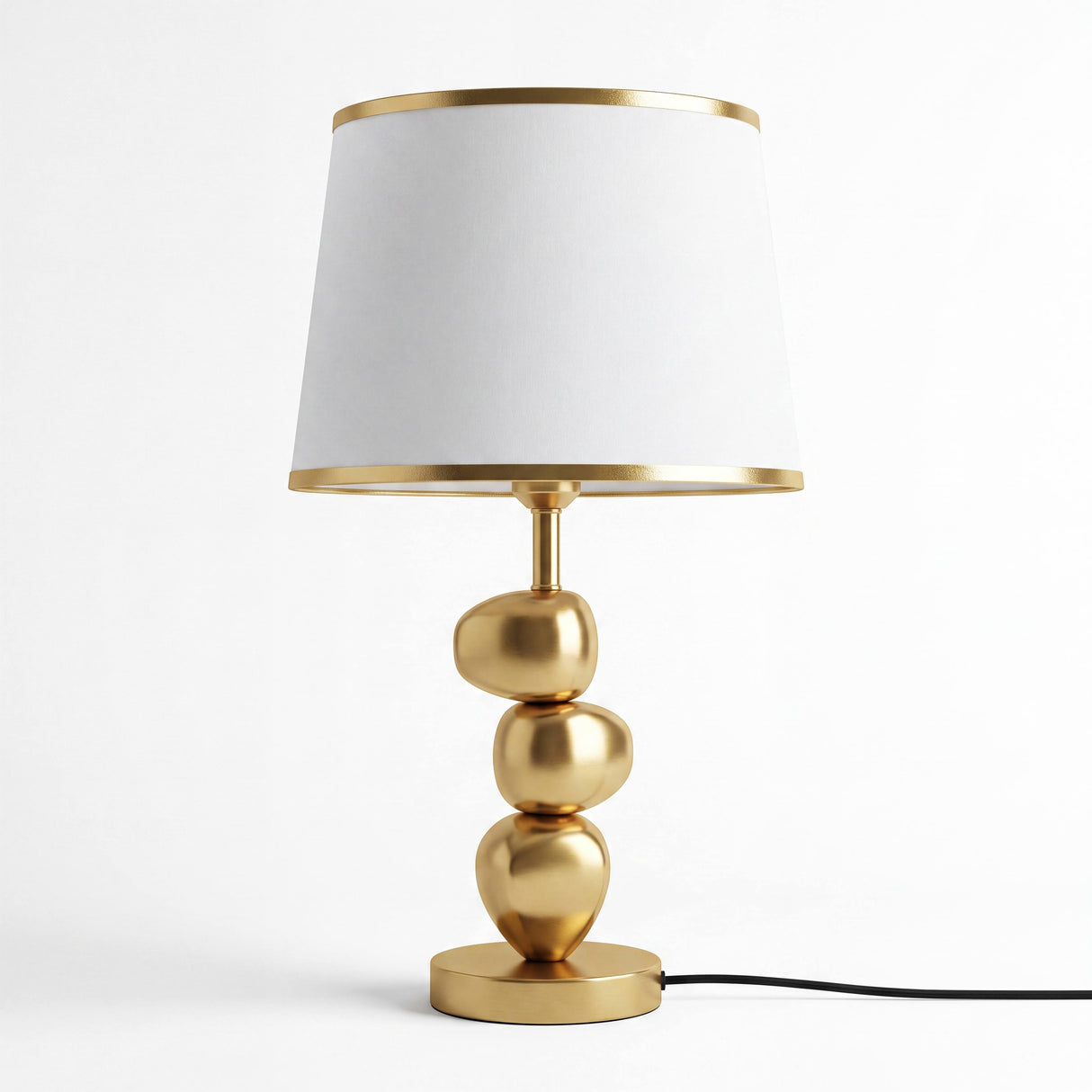 Lámpara de mesa dorada PIETRA GOLD con pantalla blanca sobre fondo neutro