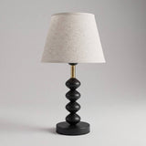 Lámpara de mesa GRETA BLACK con esferas negras sobre fondo gris neutro