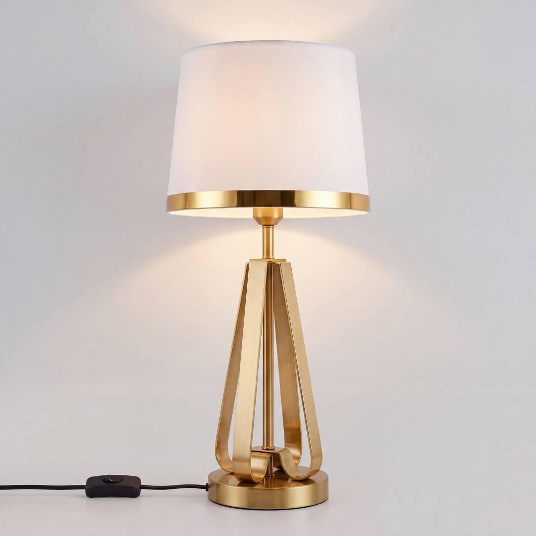 Lámpara de mesa dorada encendida con su pantalla blanca brillando cálida