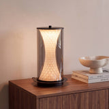 Lámpara de mesa LED ONIX Black encendida sobre aparador de nogal con luz cálida