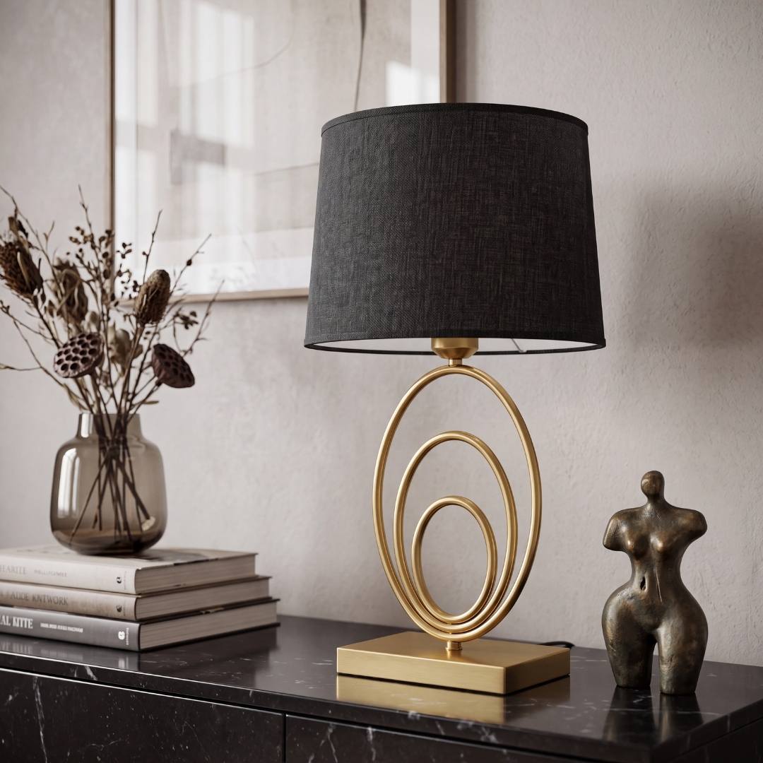 Lámpara de anillos dorados encendida junto a florero en ambiente elegante