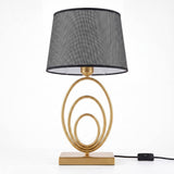 Lámpara de mesa Luna Gold con anillos dorados sobre fondo blanco