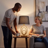 Pareja conversando junto a la luz cálida de la lámpara de anillos dorados