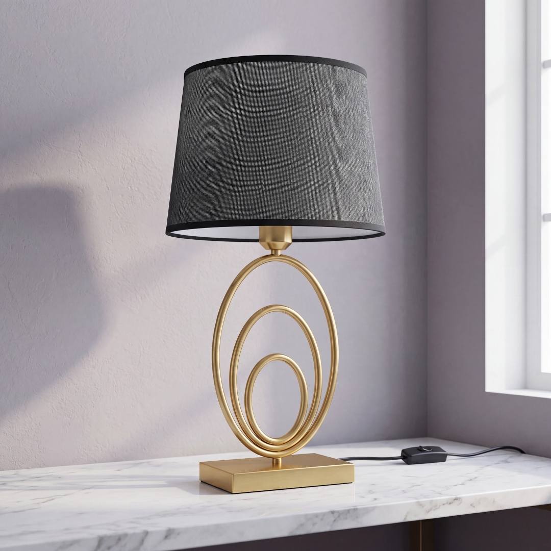Lámpara de mesa con anillos dorados y pantalla gris sobre mesa de mármol
