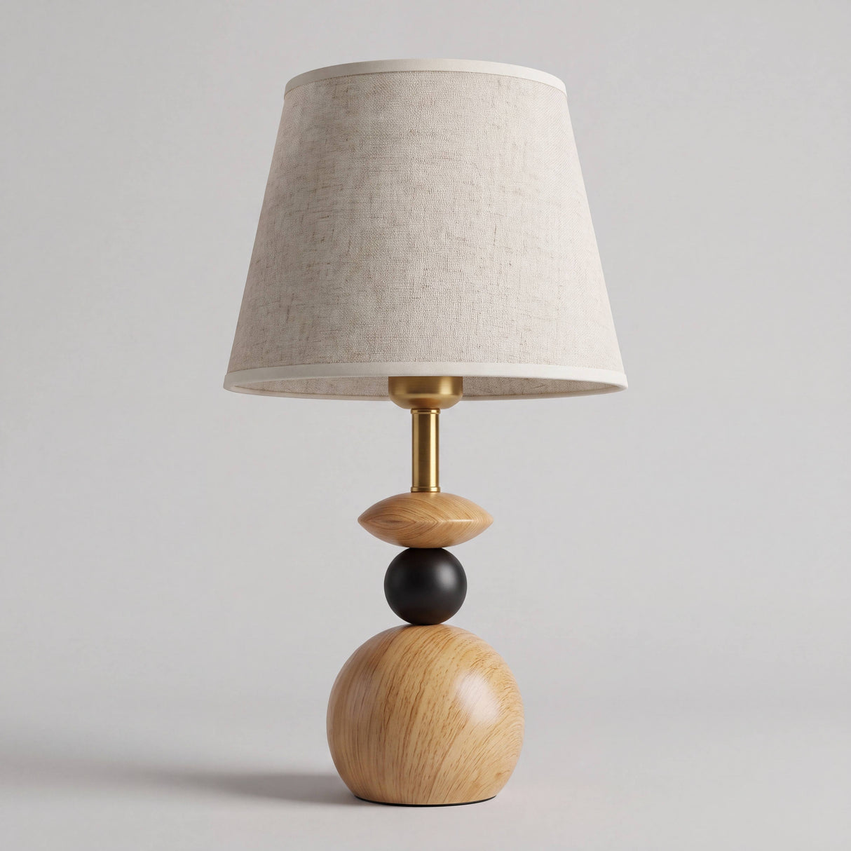 Lámpara de mesa FREYA con base de esferas de madera sobre fondo neutro