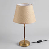 Lámpara de mesa MARGOT WALNUT AND GOLD encendida en ambiente claro y luminoso