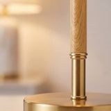 Primer plano de la columna color madera clara con collar dorado de la lámpara MARGOT