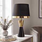 Lámpara de mesa negra con detalles dorados CLEO GOLD sobre fondo neutro