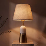 Lámpara de mesa Olivia Gold con base dorada, cuerpo de aluminio blanca y pantalla de tela beige