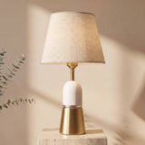 Lámpara de mesa Olivia Gold con base dorada, cuerpo de aluminio blanca y pantalla de tela beige