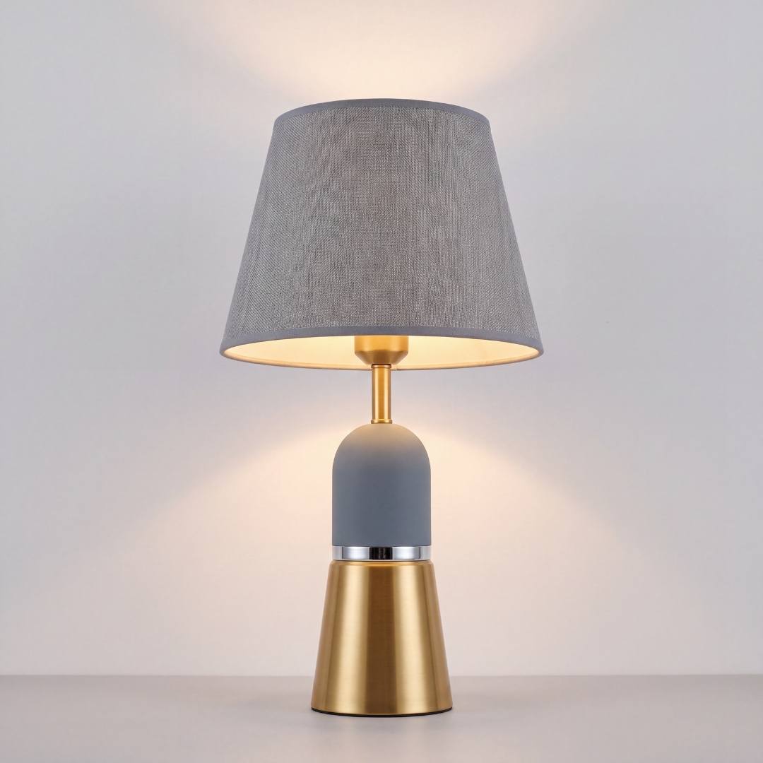 Lámpara de mesa OLIVIA GREY encendida con luz cálida en ambiente oscuro
