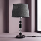 Lámpara de mesa negra con cristal y cromo sobre mesa junto a la ventana