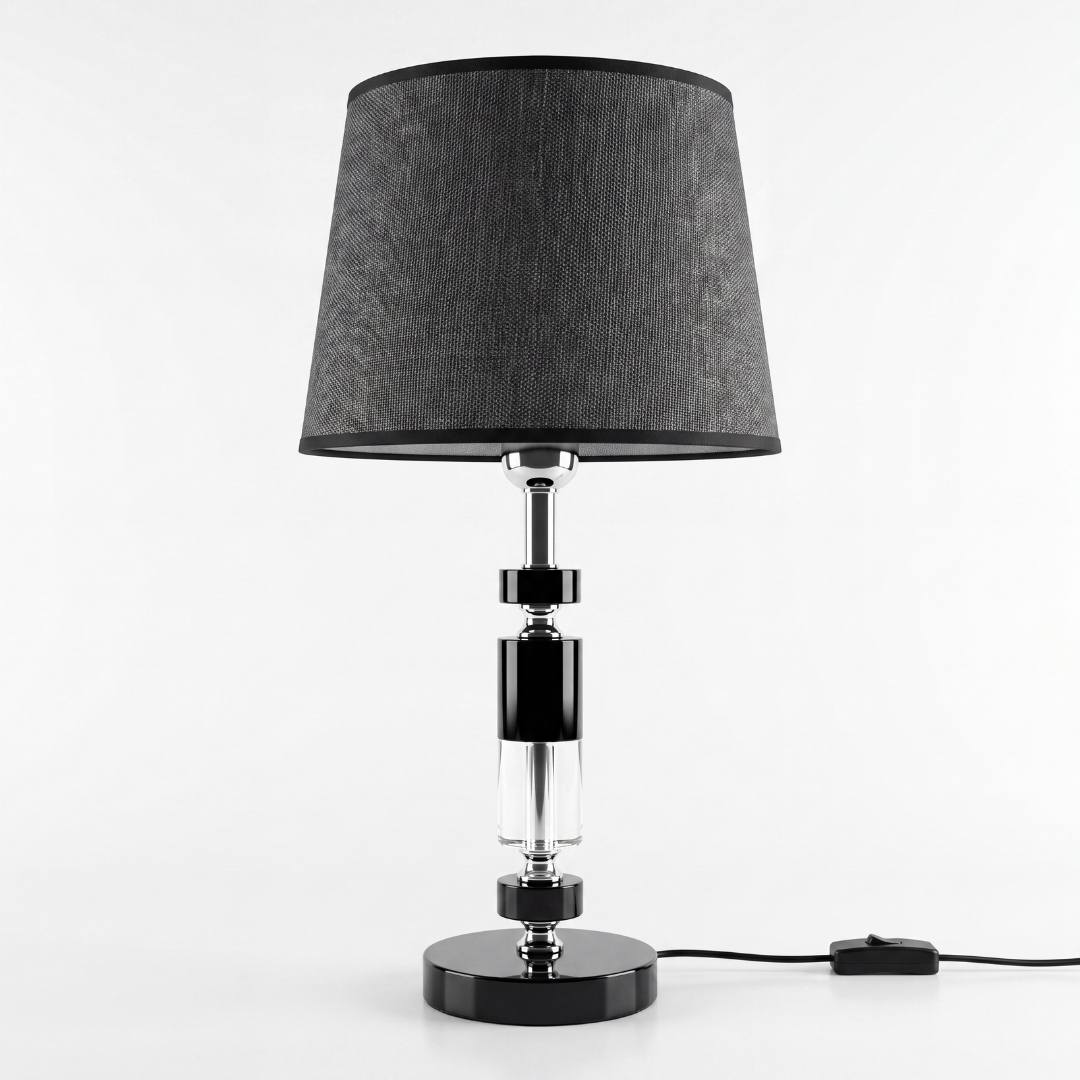 Lámpara de mesa negra con columna de cristal sobre superficie clara