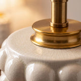 Primer plano de la cerámica craquelada crema con burbujas y collar dorado de la lámpara PERLA