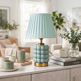 Lámpara de mesa verde menta con dorado decorando un ambiente luminoso