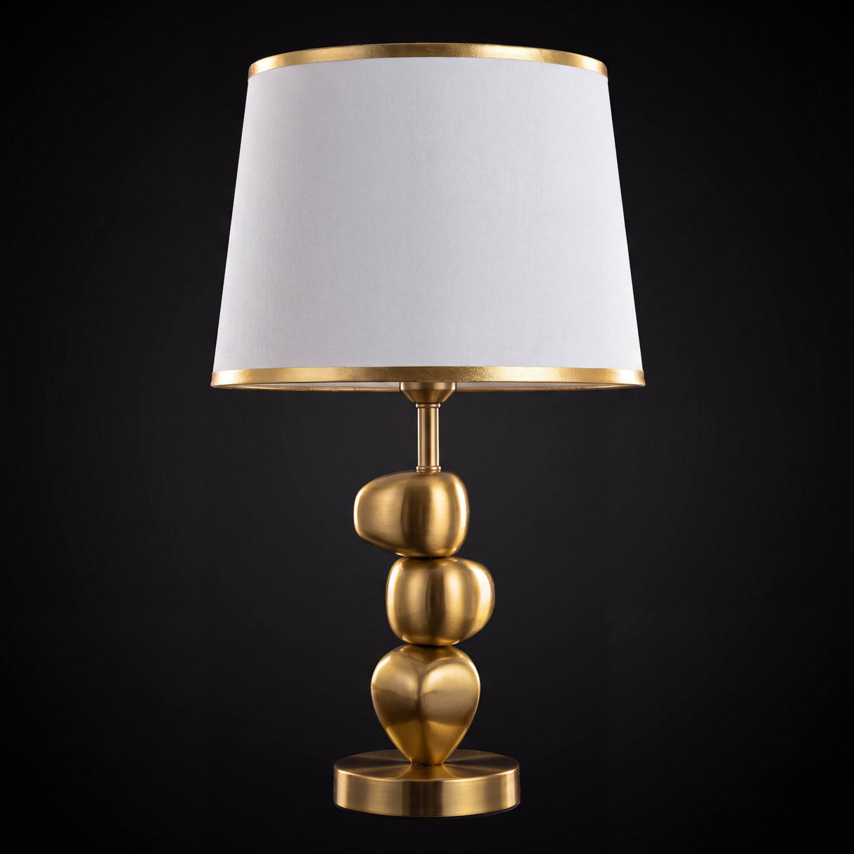 Lámpara de mesa PIETRA GOLD con piedras doradas brillantes sobre fondo oscuro