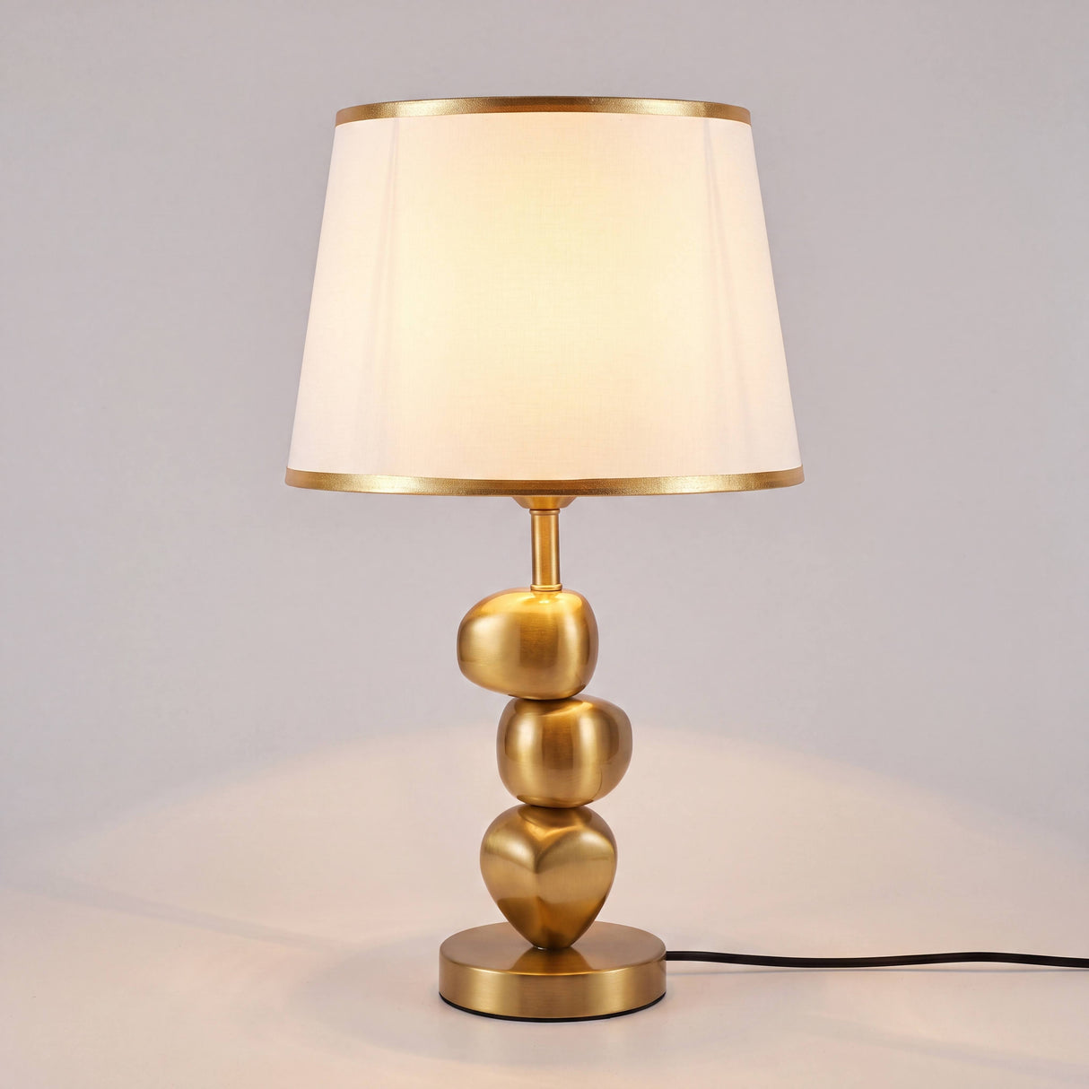 Vista completa de la lámpara de mesa PIETRA GOLD con base escultural dorada