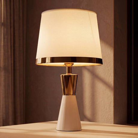 Lámpara de mesa CLEO GOLD blanca con aro dorado en ambiente luminoso