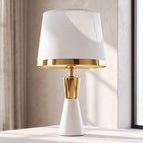 Lámpara de mesa CLEO GOLD blanca con aro dorado en ambiente luminoso