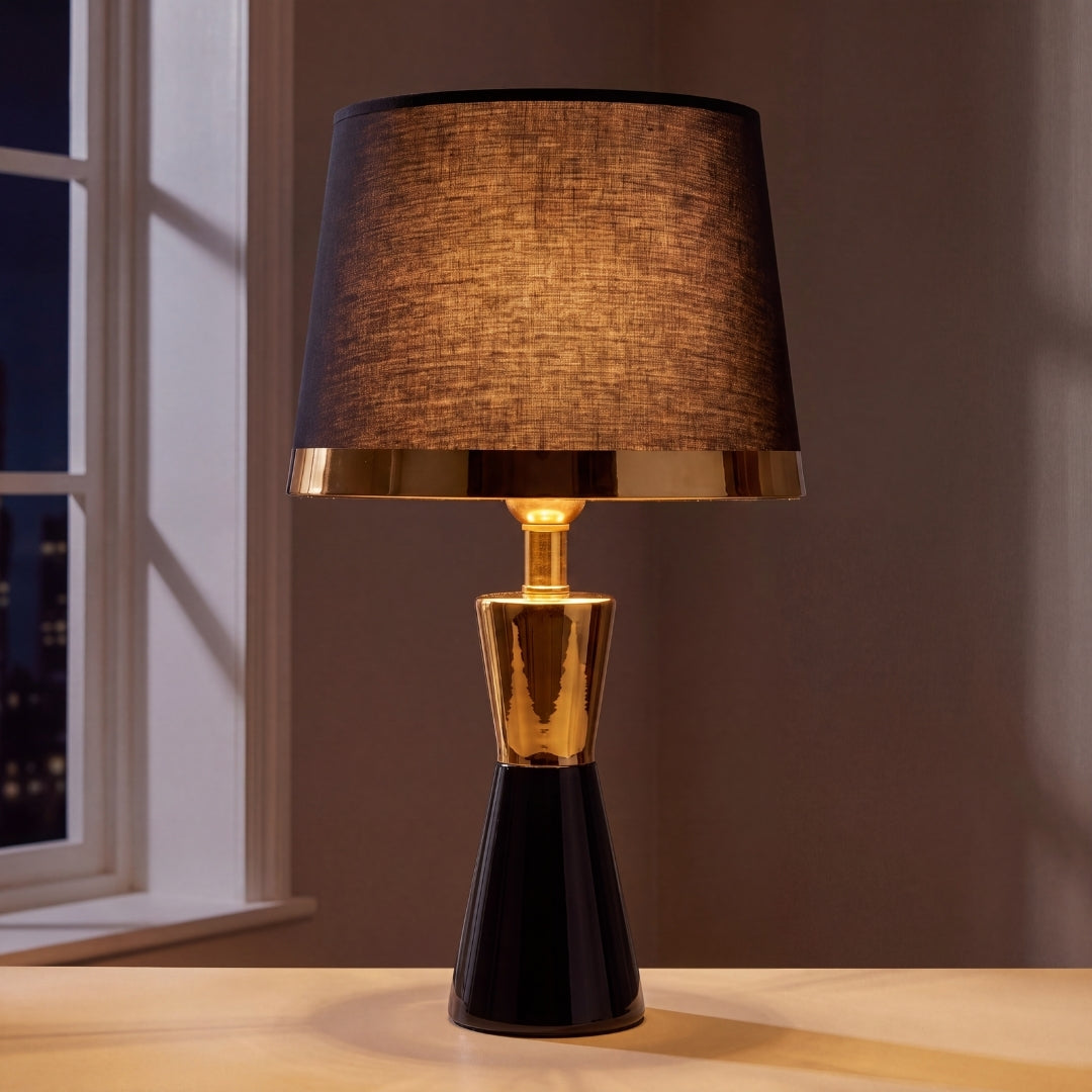 Lámpara de mesa CLEO GOLD negra con aro dorado junto a ventana luminosa