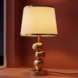 Lámpara de mesa PIETRA GOLD dorada con base de piedras y pantalla blanca