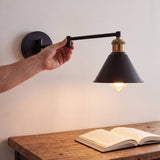 Mano extendiendo el brazo de la lámpara de pared articulable ELSA