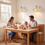Familia desayunando en un comedor iluminado por apliques SOHO blancos