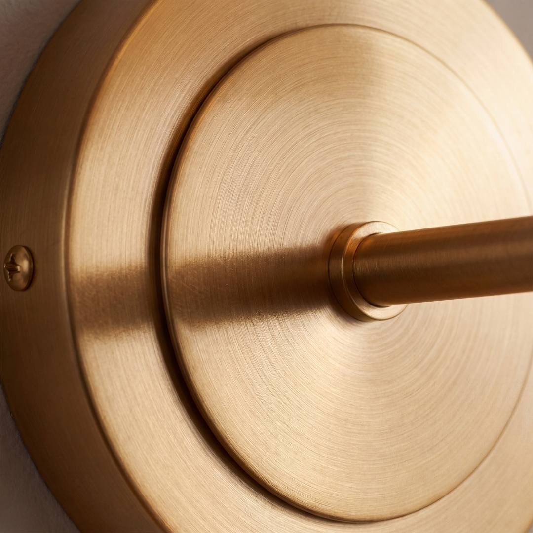 Detalle de la base circular dorada satinada de la lámpara de pared GALA