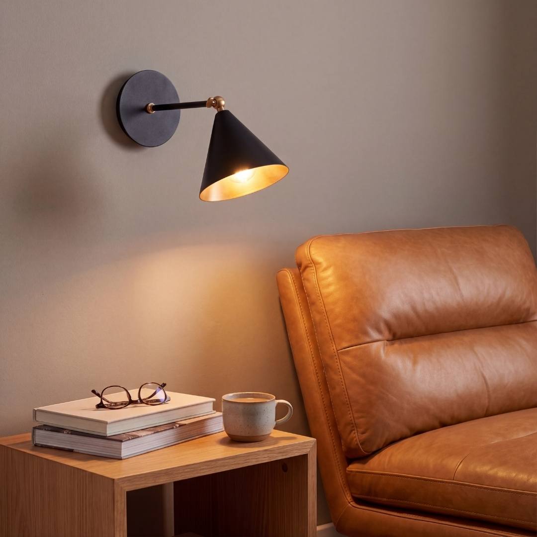 Lámpara de pared BRERA sobre un sillón de cuero en un rincón de lectura
