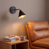 Lámpara de pared BRERA sobre un sillón de cuero en un rincón de lectura