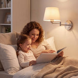 Mamá e hija leyendo en la cama bajo una lámpara de pared GALA níquel