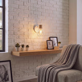 Lámpara de pared con luz cálida en rincón de lectura con sillón