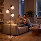 Pareja conversando en el sofá bajo la luz cálida de la lámpara de pie