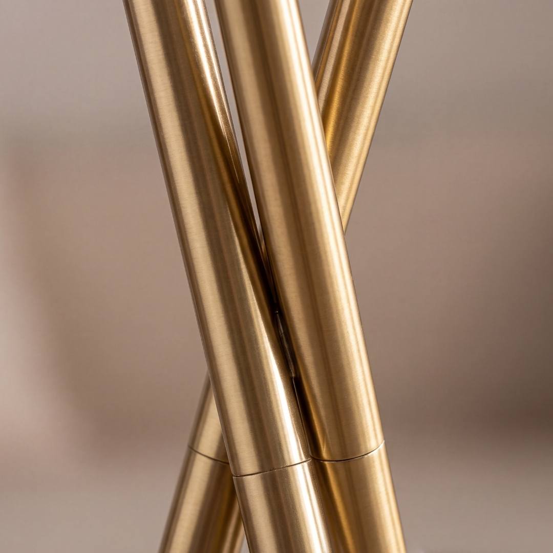 Detalle del nudo entrelazado de las tres patas doradas de la lámpara TRINA GOLD
