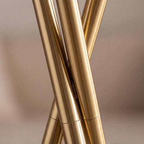 Detalle del nudo entrelazado de las tres patas doradas de la lámpara TRINA GOLD