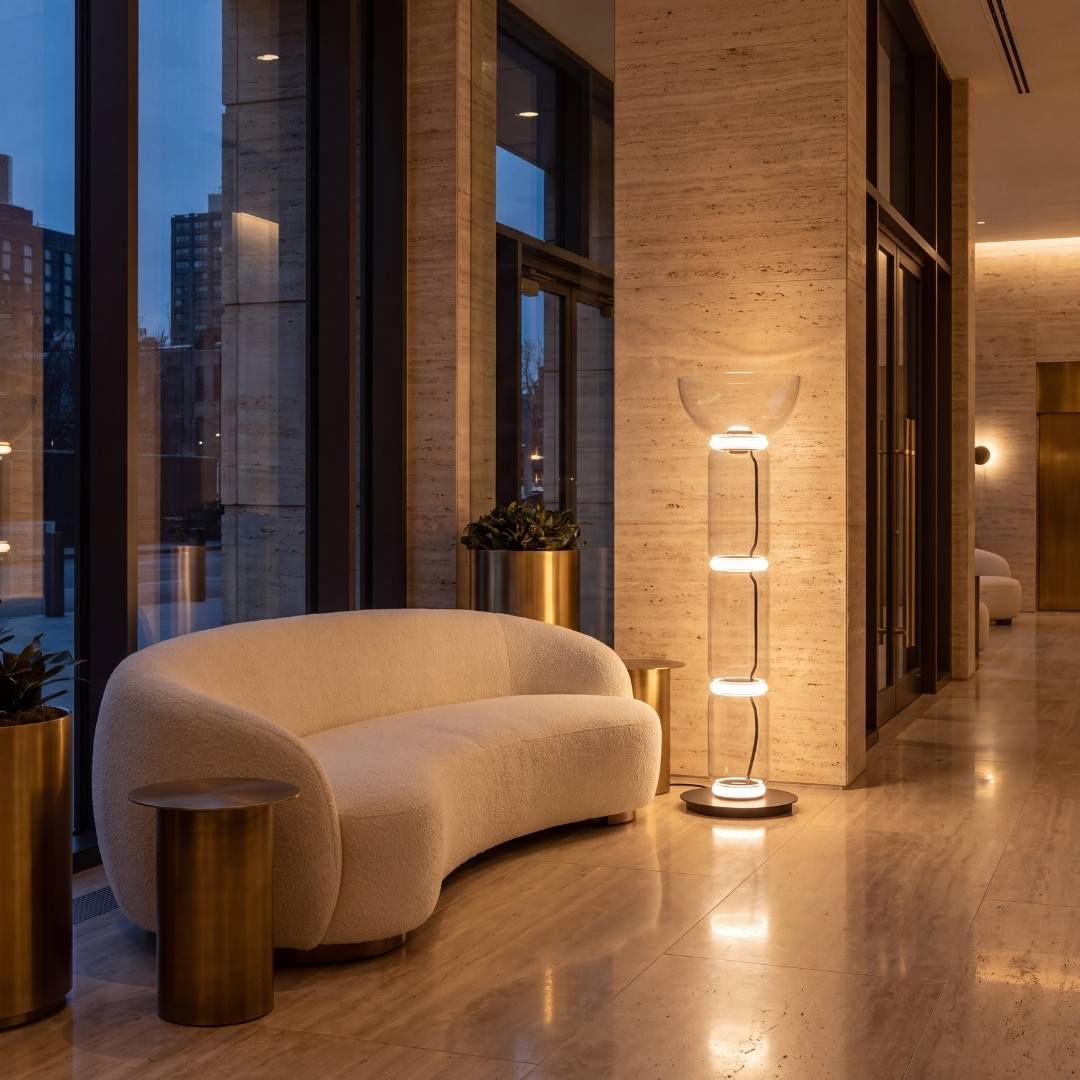 Lámpara de pie LED ALTEA iluminando un lobby elegante con sofá curvo