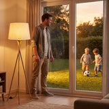 Padre e hijo junto a la ventana con la lámpara de pie para sala encendida