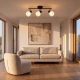 Lámpara de techo de 3 luces iluminando una sala moderna con sofá y cuadro
