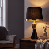 Lámpara decorativa negra y dorada iluminando ambiente de sala contemporánea