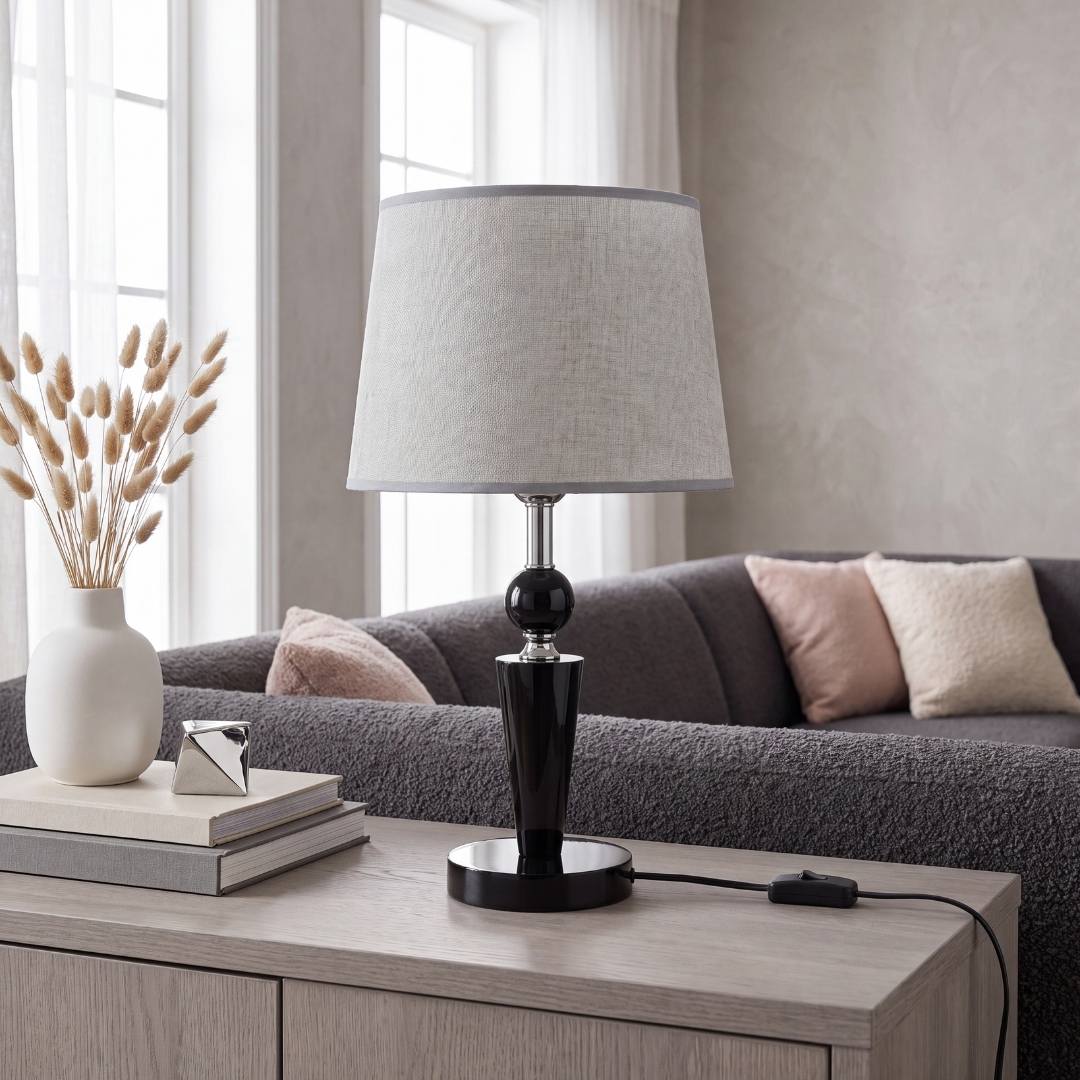 Lámpara decorativa negra con pantalla gris junto a flores en la sala