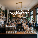 Iluminacion decorativa calida sobre barra de cafeteria de especialidad moderna.