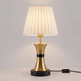 Lámpara decorativa COCO GOLD AND BLACK en mesa auxiliar de sala con sofá claro