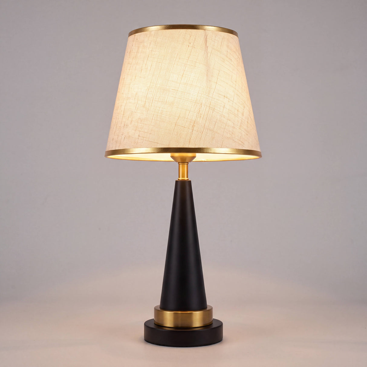 Lámpara decorativa beige y negra sobre consola con flores secas en sala elegante