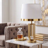 Lámpara decorativa dorada en mesa auxiliar de sala luminosa