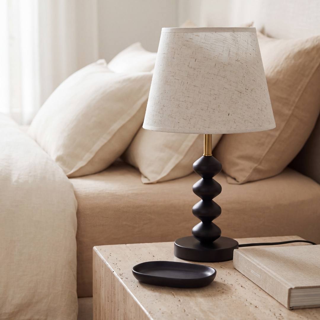 Lámpara decorativa GRETA BLACK en mesa auxiliar de sala con sofá blanco