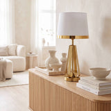 Lámpara decorativa dorada en mesa auxiliar de sala luminosa